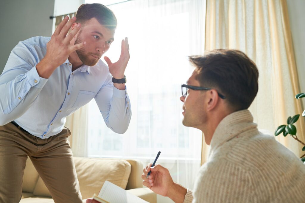 Young man expressing his feelings at appointment with psychiatri